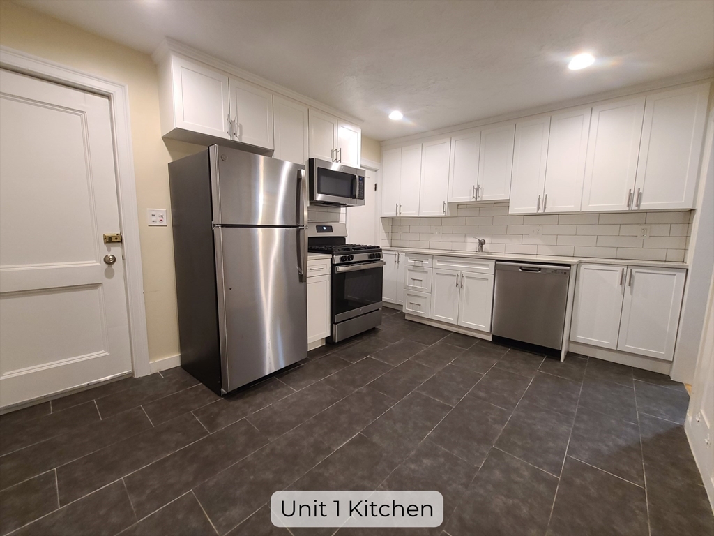 a kitchen with stainless steel appliances granite countertop a refrigerator and a stove top oven