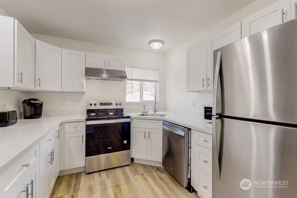 a kitchen with stainless steel appliances a refrigerator sink and stove