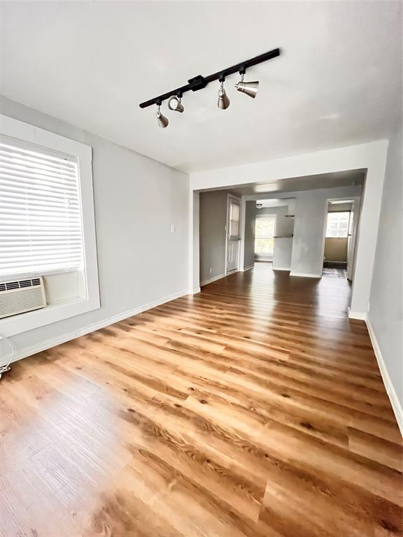 a view of empty room with wooden floor and windows