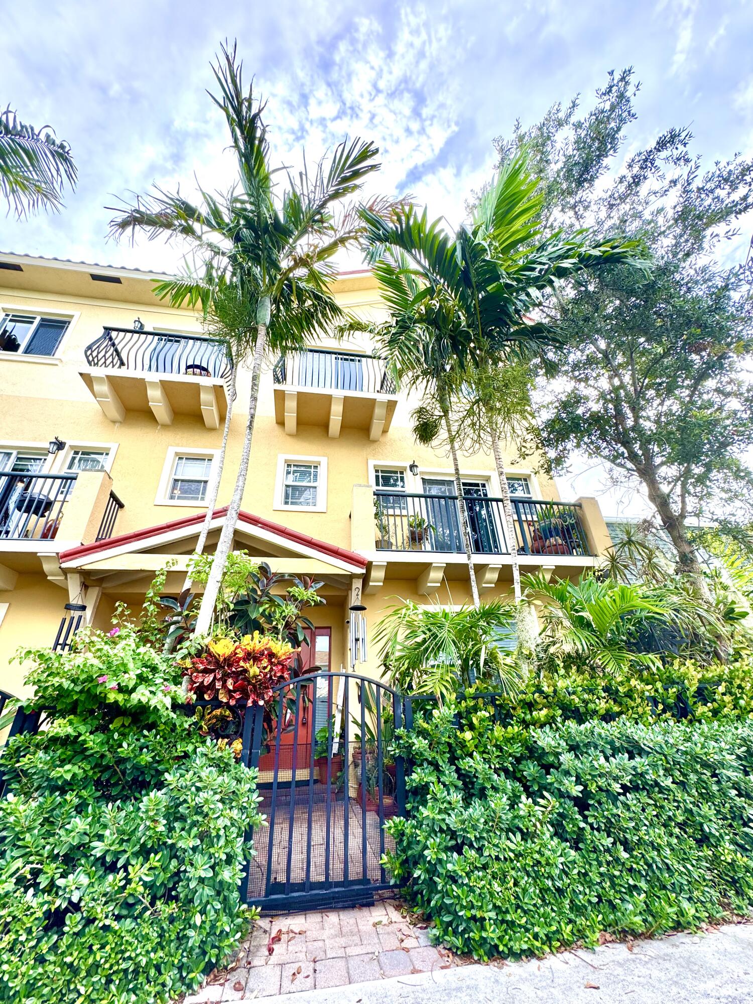 a front view of a multi story residential apartment building with a garden