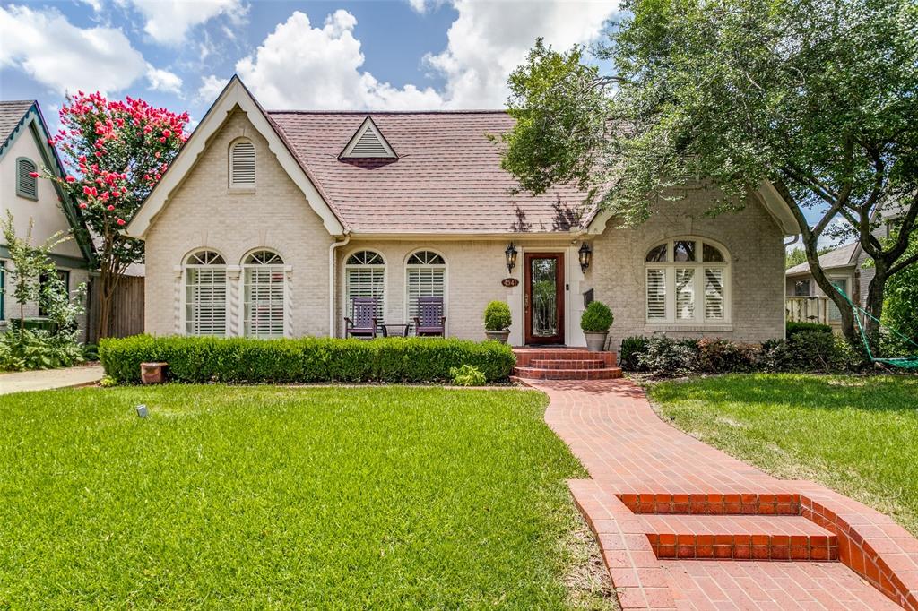 a front view of a house with a yard and potted plants