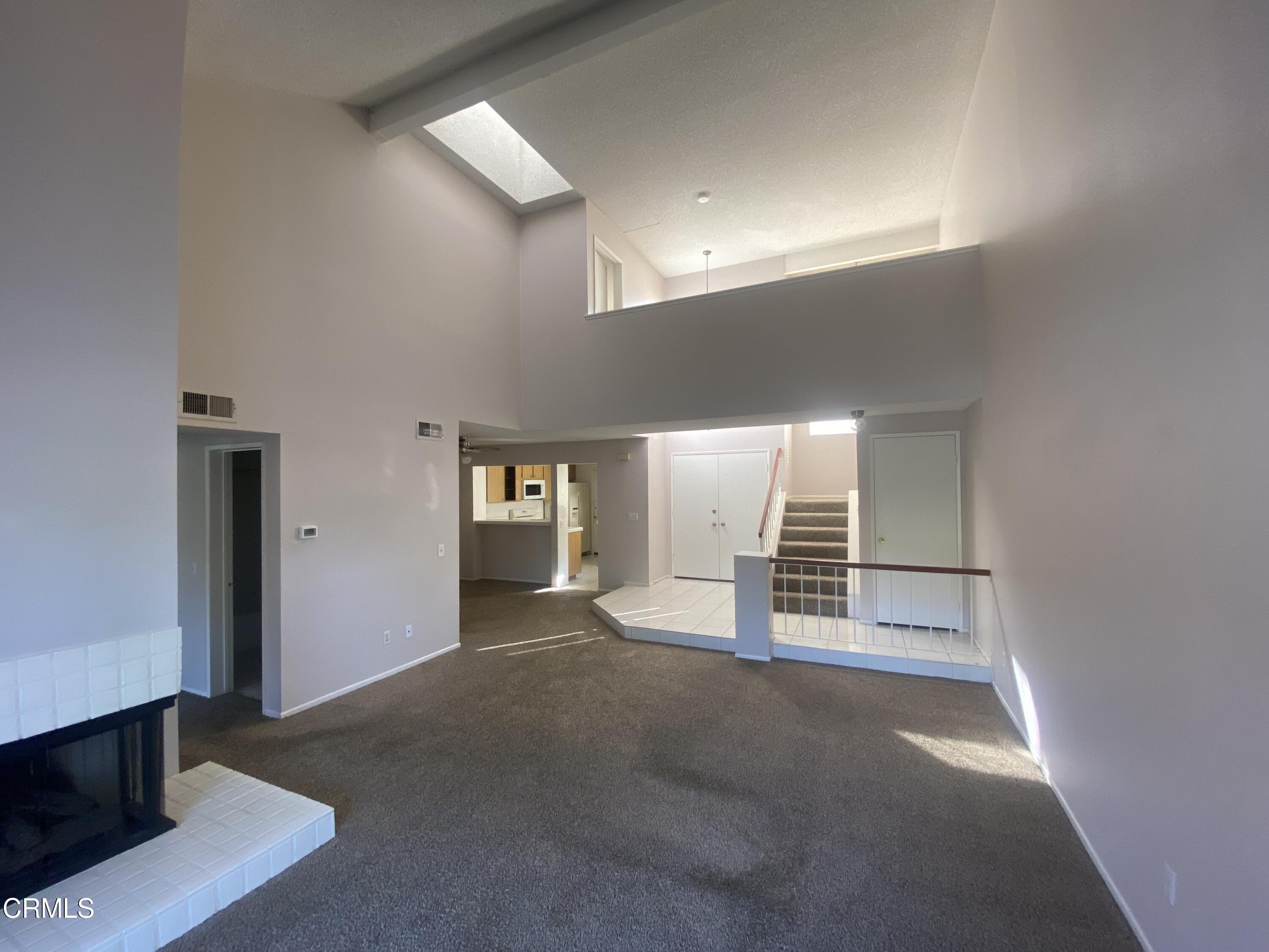 a view of a hallway with wooden floor and cabinet