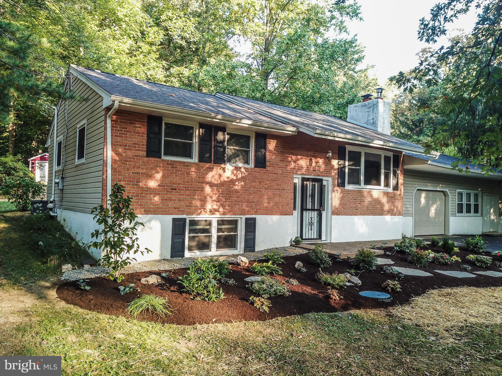 a front view of a house with a garden and plants