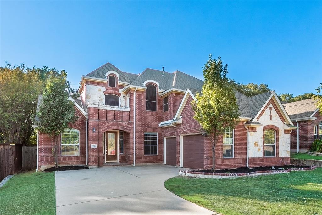 View of front of property with a front yard and a garage