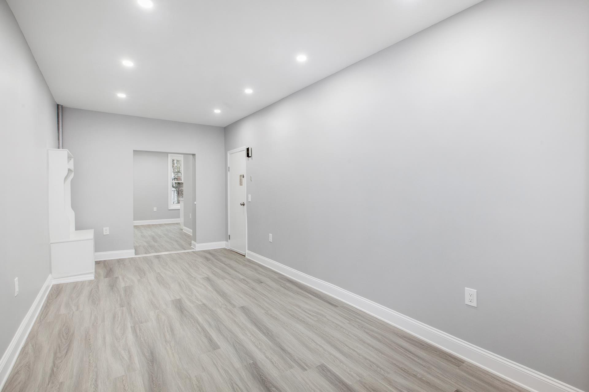 a view of an empty room with wooden floor