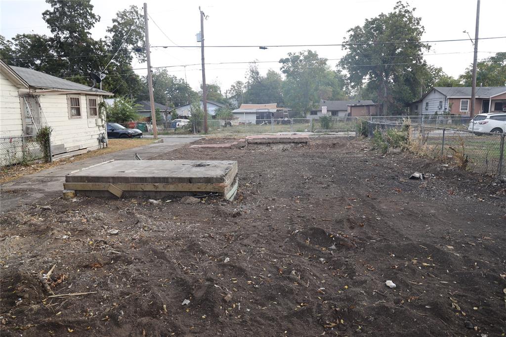 a view of a yard with wooden fence