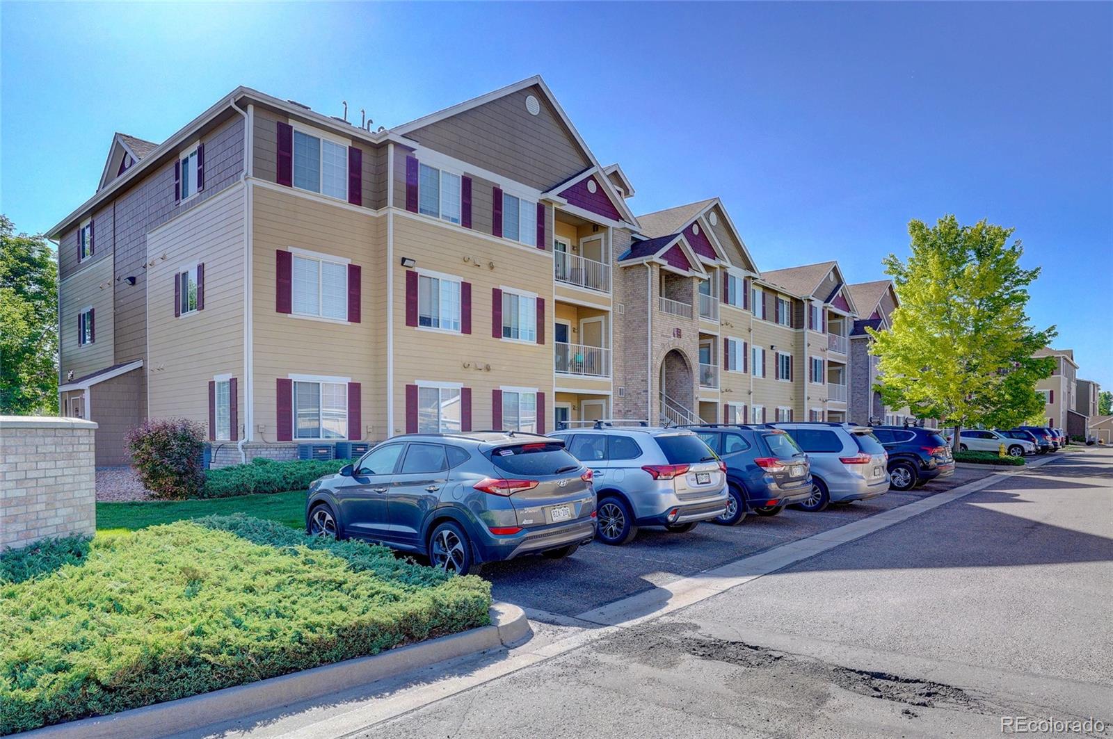 a front view of a building with cars parked