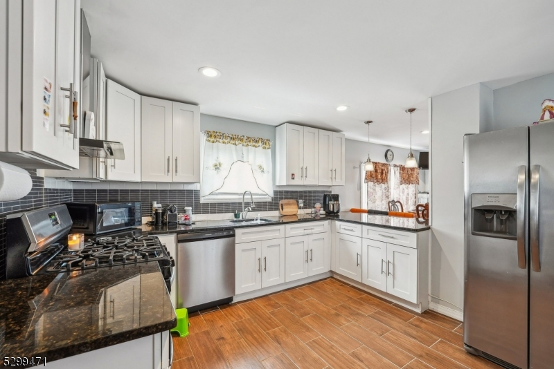 a kitchen with stainless steel appliances granite countertop a stove a sink and a refrigerator