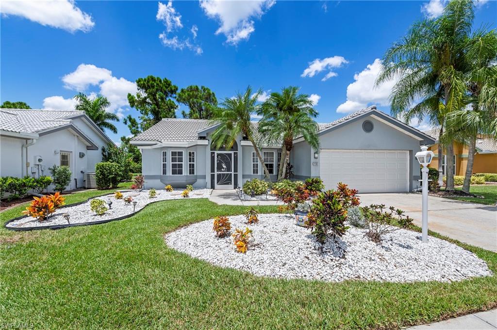 Mediterranean / spanish-style house featuring a garage, central AC, and a front yard