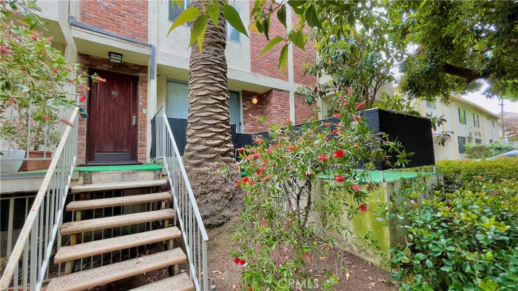 a front view of a multi story residential apartment building with yard