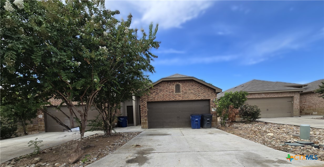 a view of a house with a yard and tree