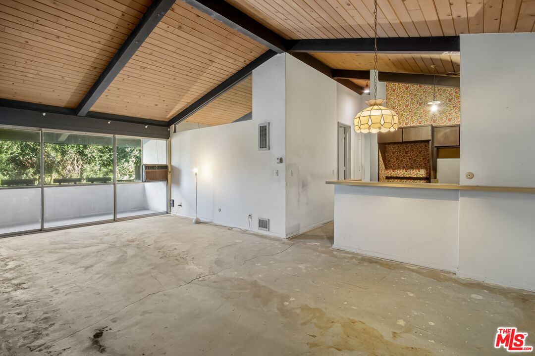 an empty room with a fireplace and a large window