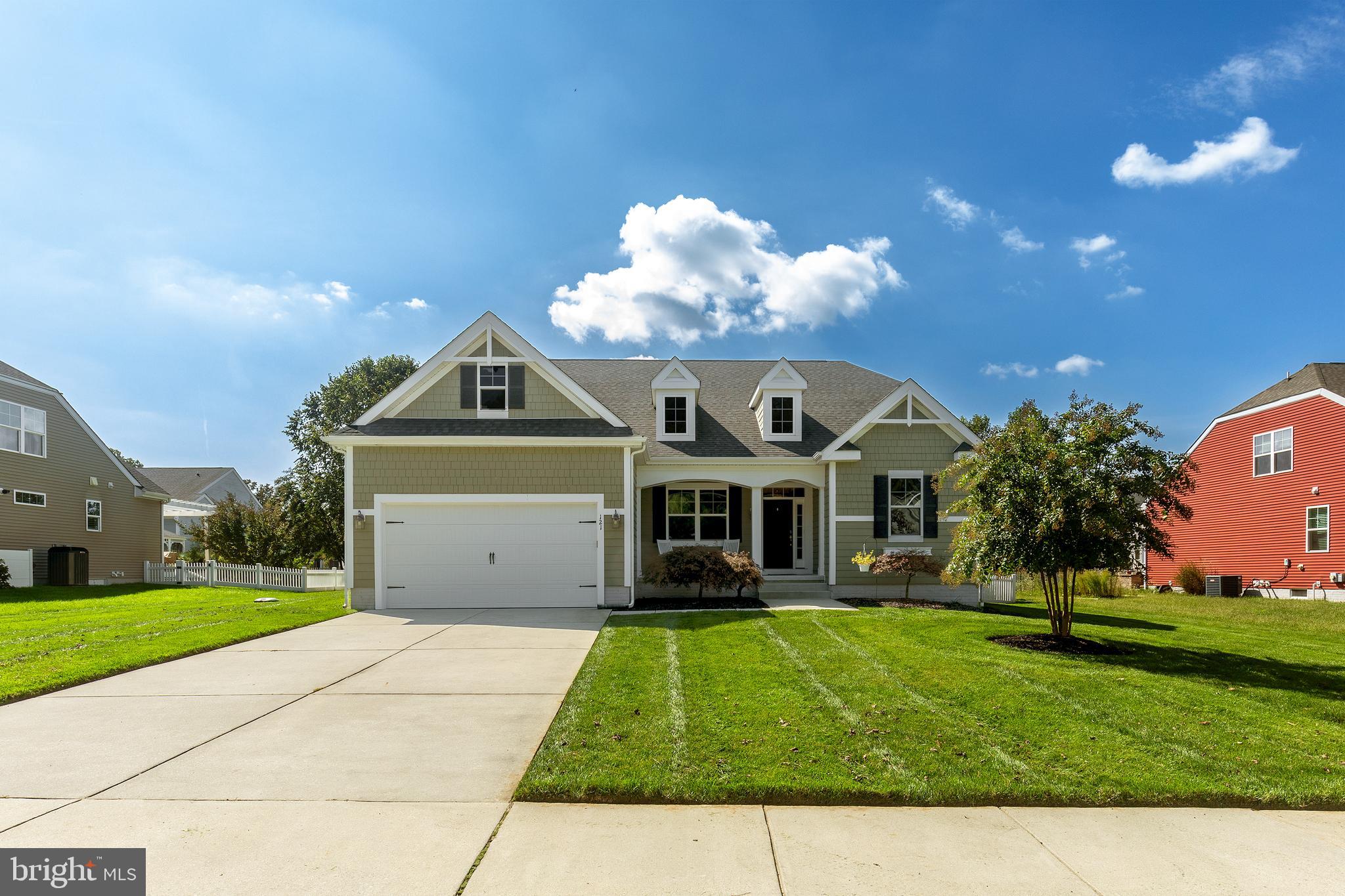 a front view of a house with a yard and potted plants