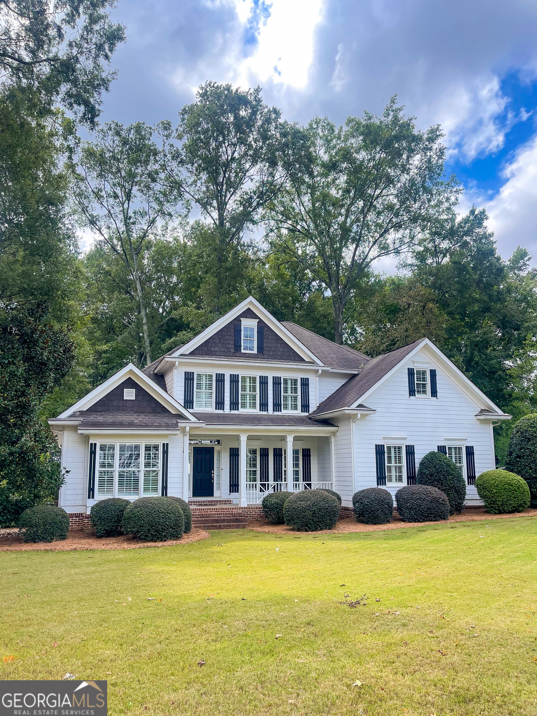 a front view of a house with yard and green space