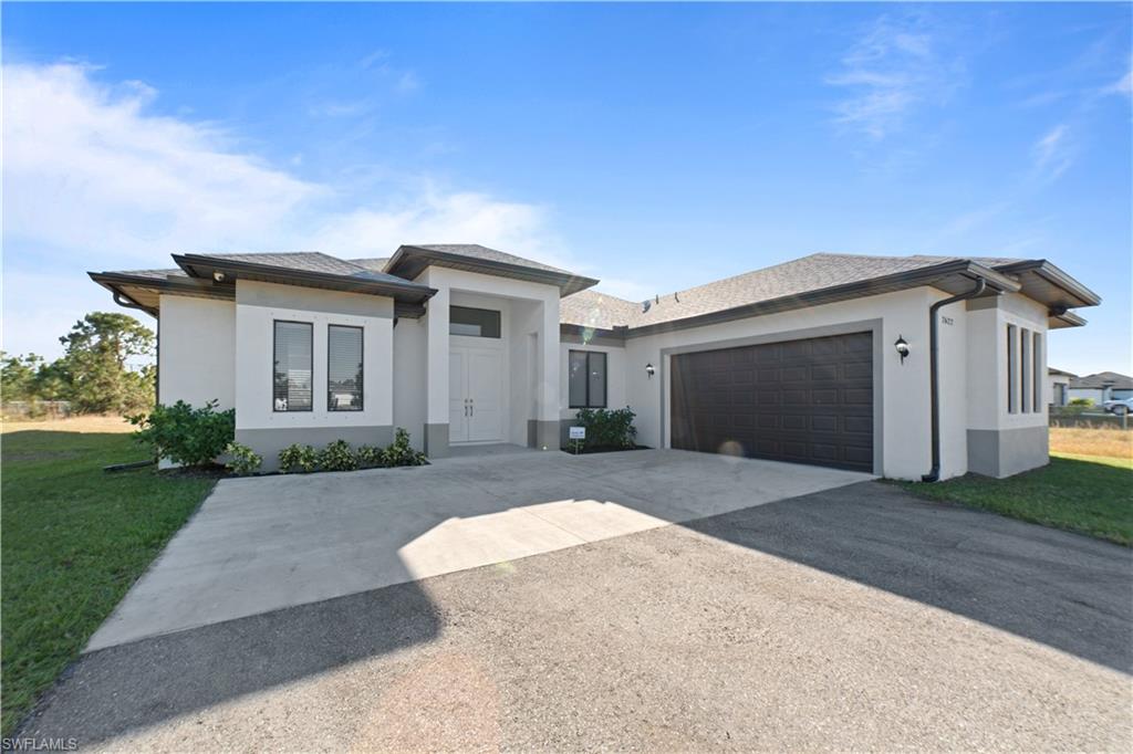 a front view of a house with a yard and garage