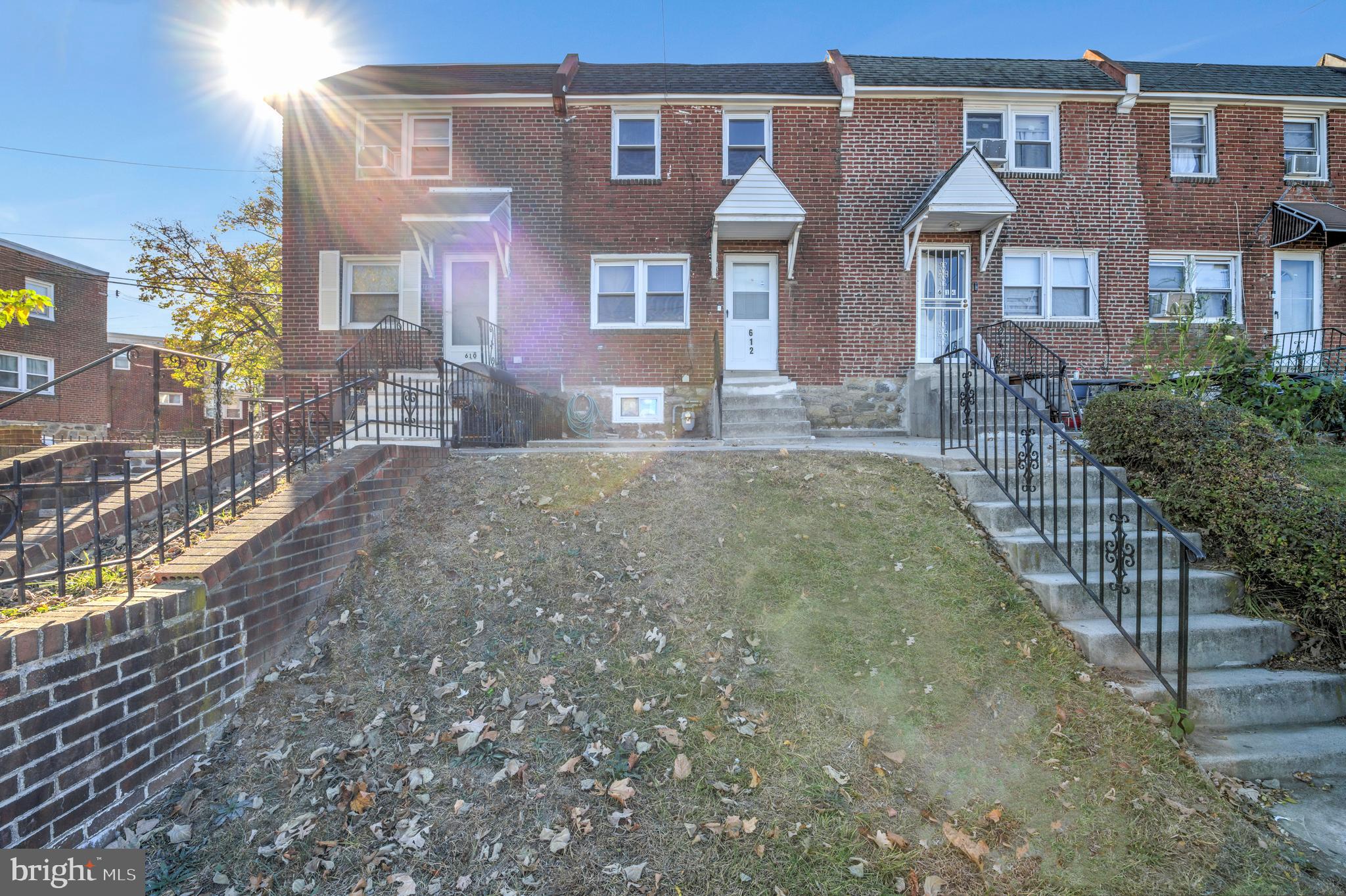 a view of a brick house with many windows next to a yard