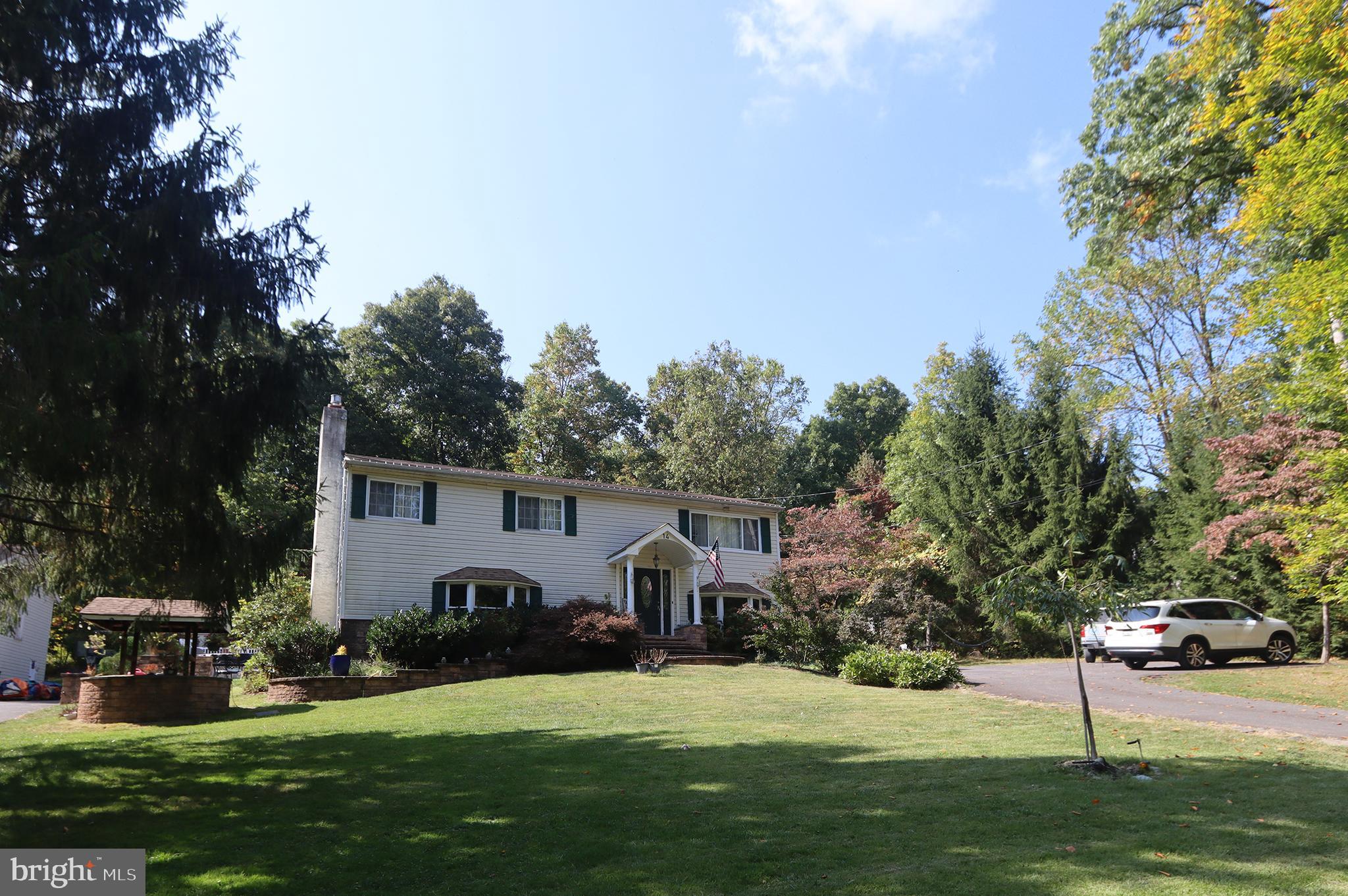 a front view of a house with a garden and trees