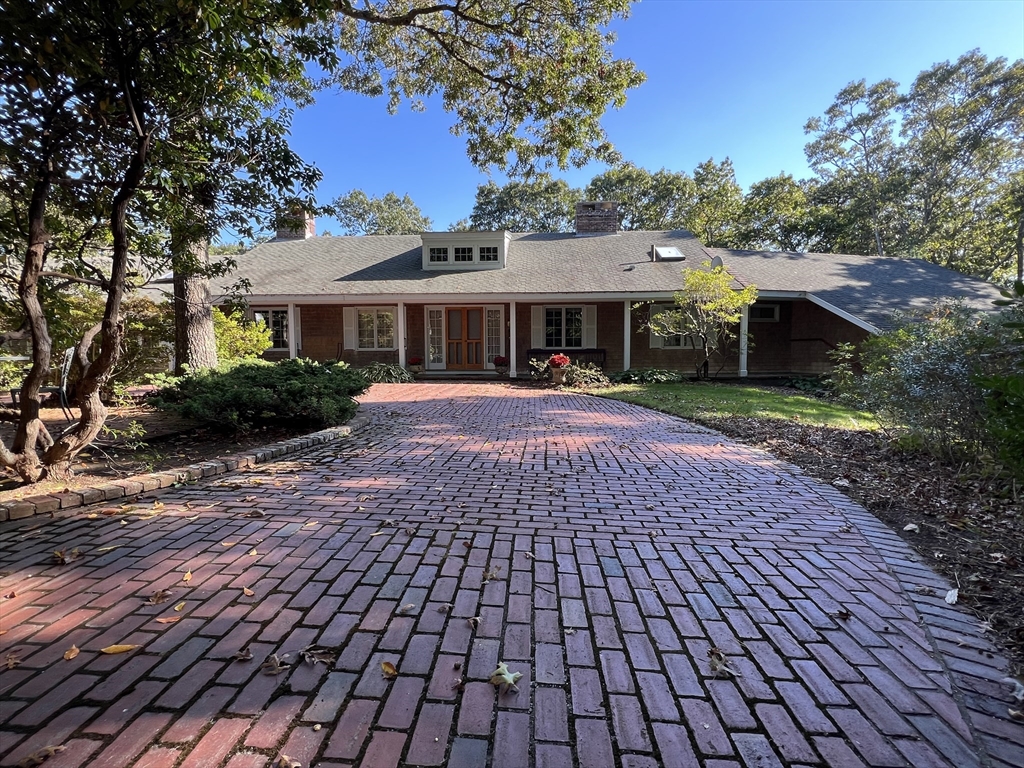 a front view of a house with a yard and trees