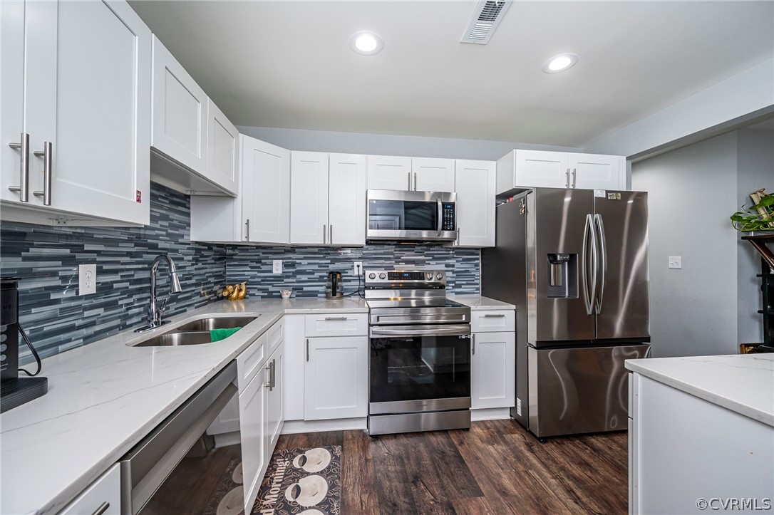 a kitchen with a refrigerator sink and wooden floor