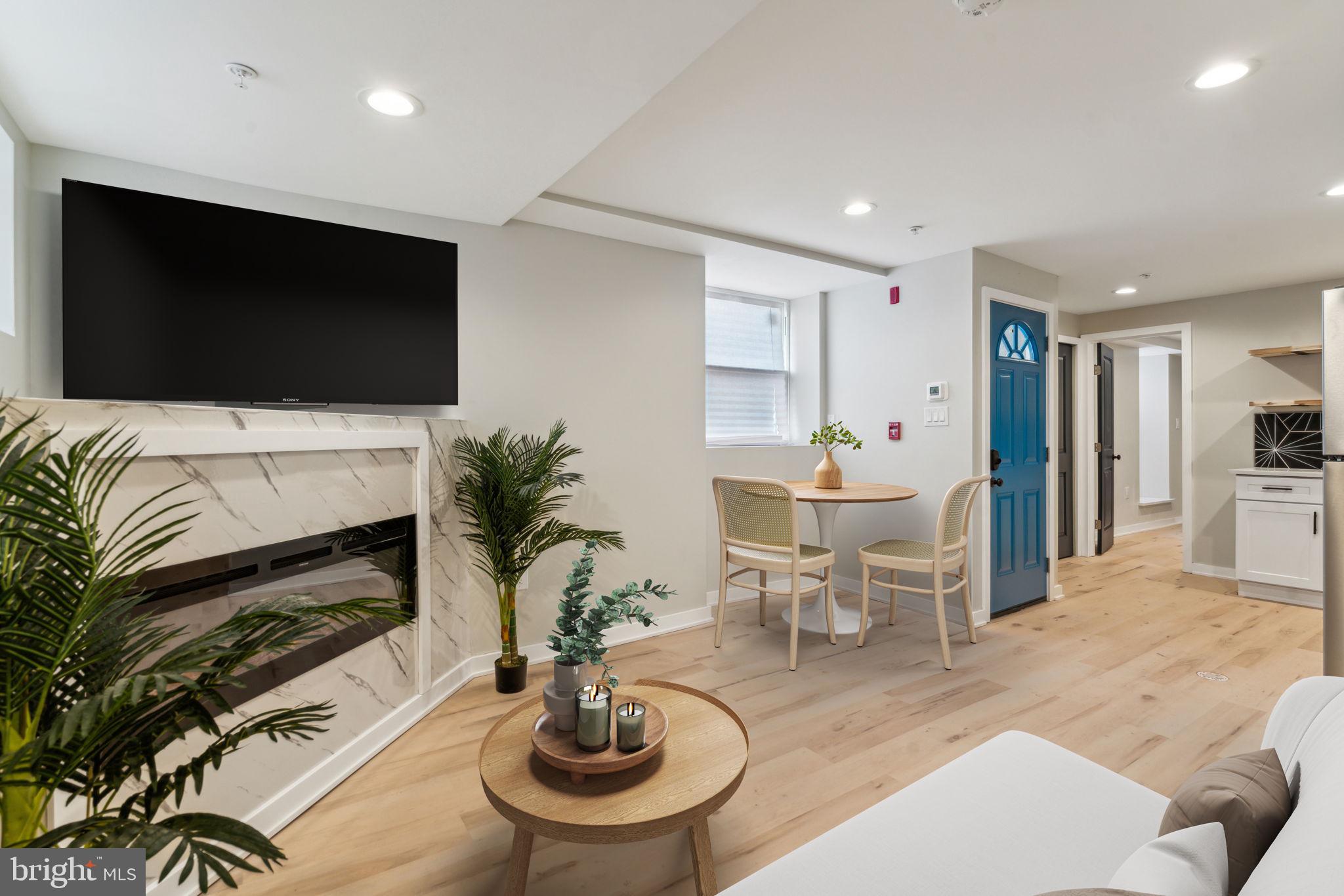 a living room with furniture a flat screen tv and kitchen view