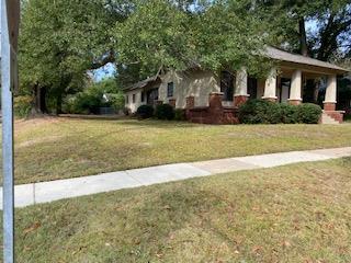 a front view of a house with a yard and trees