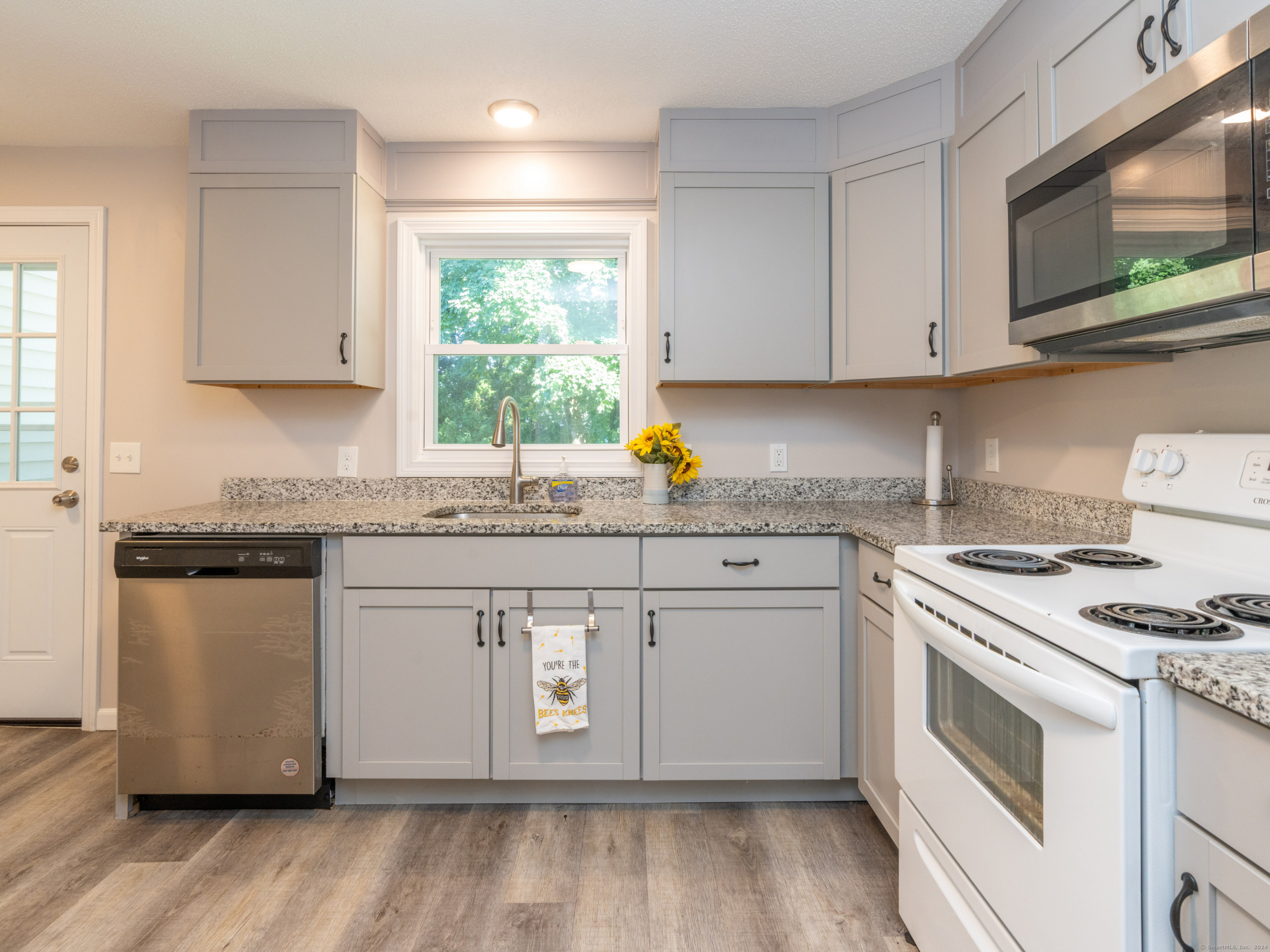 a kitchen with granite countertop white cabinets and white appliances