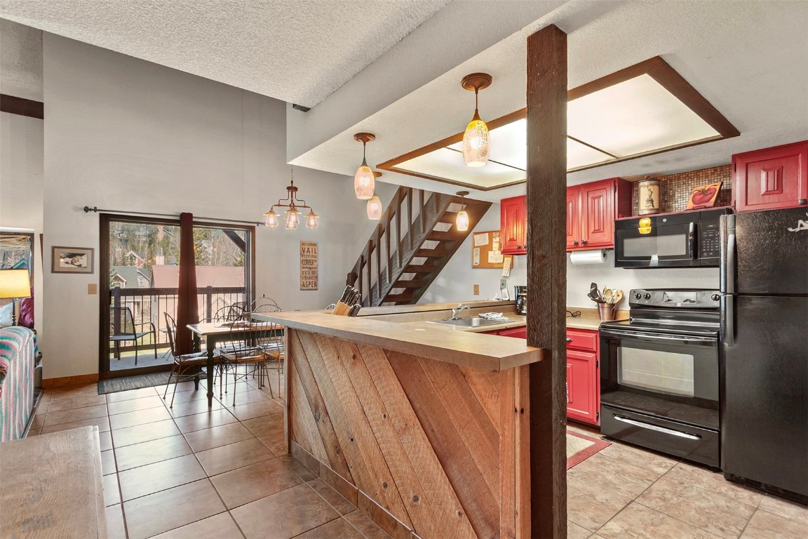 a kitchen with a stove a refrigerator and chairs