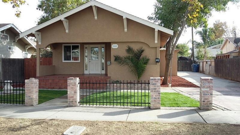 a front view of a house with a garden and plants