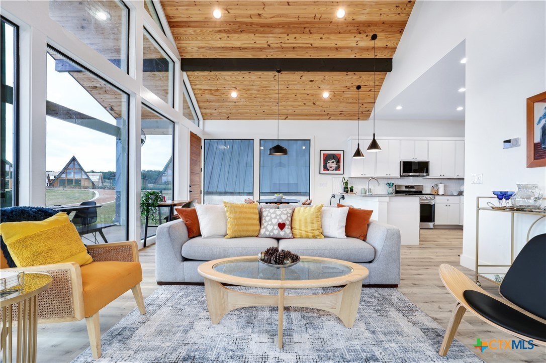 a living room with fireplace furniture and a large window