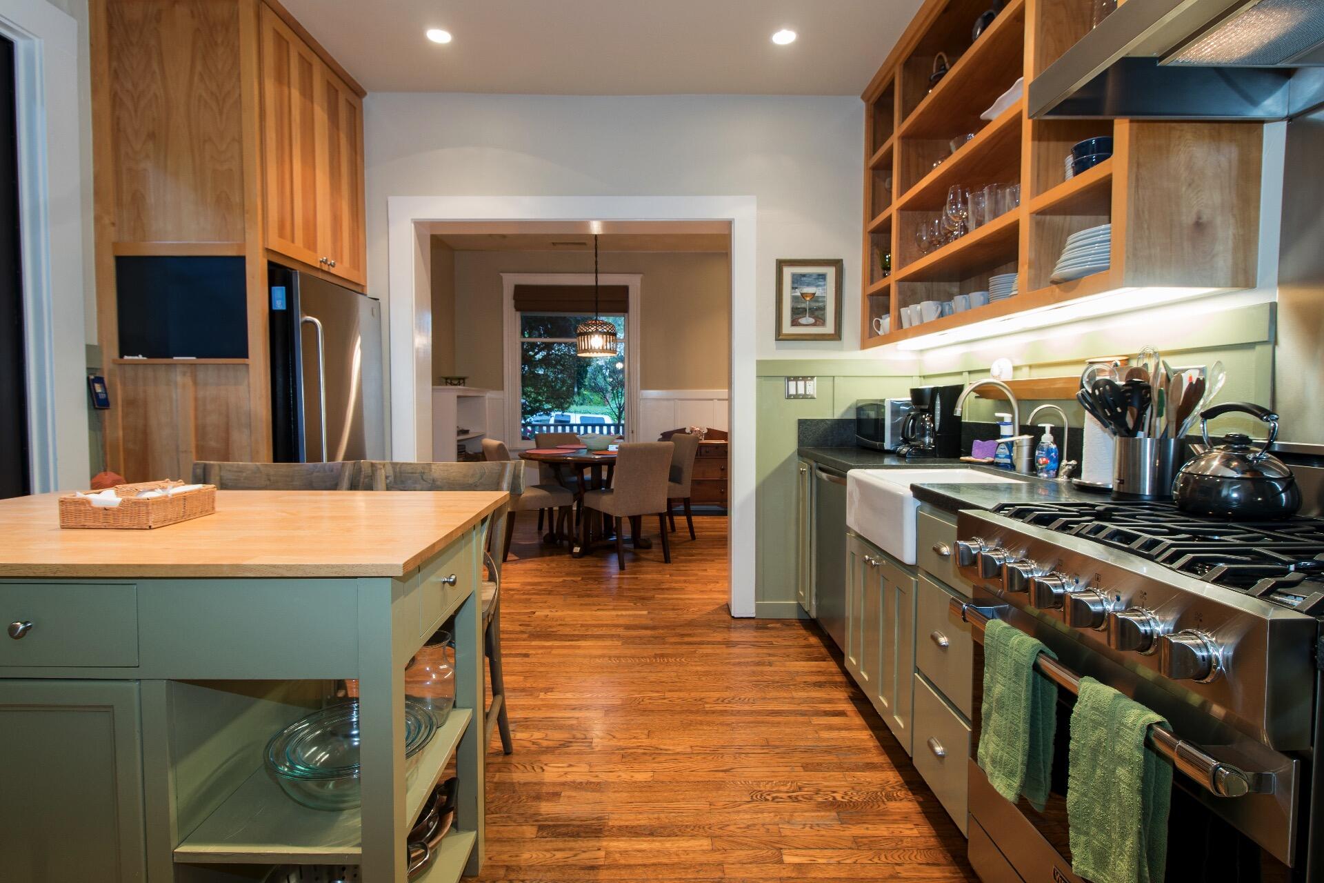 a kitchen with stainless steel appliances granite countertop a stove and a dining table