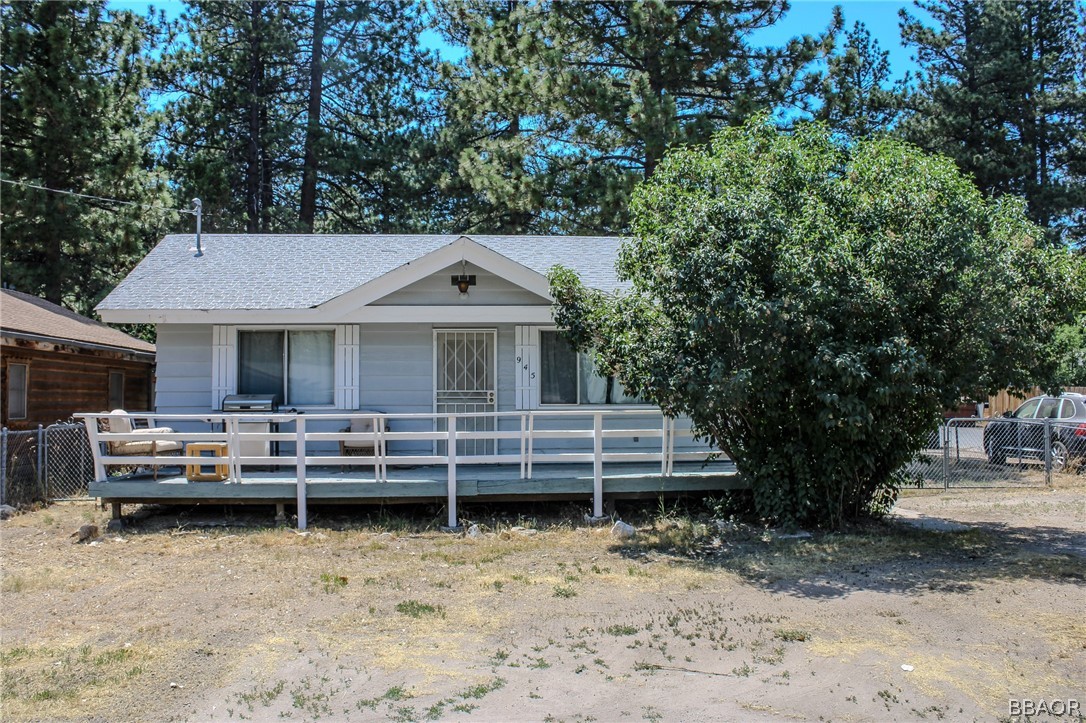 a front view of a house with a garden and trees