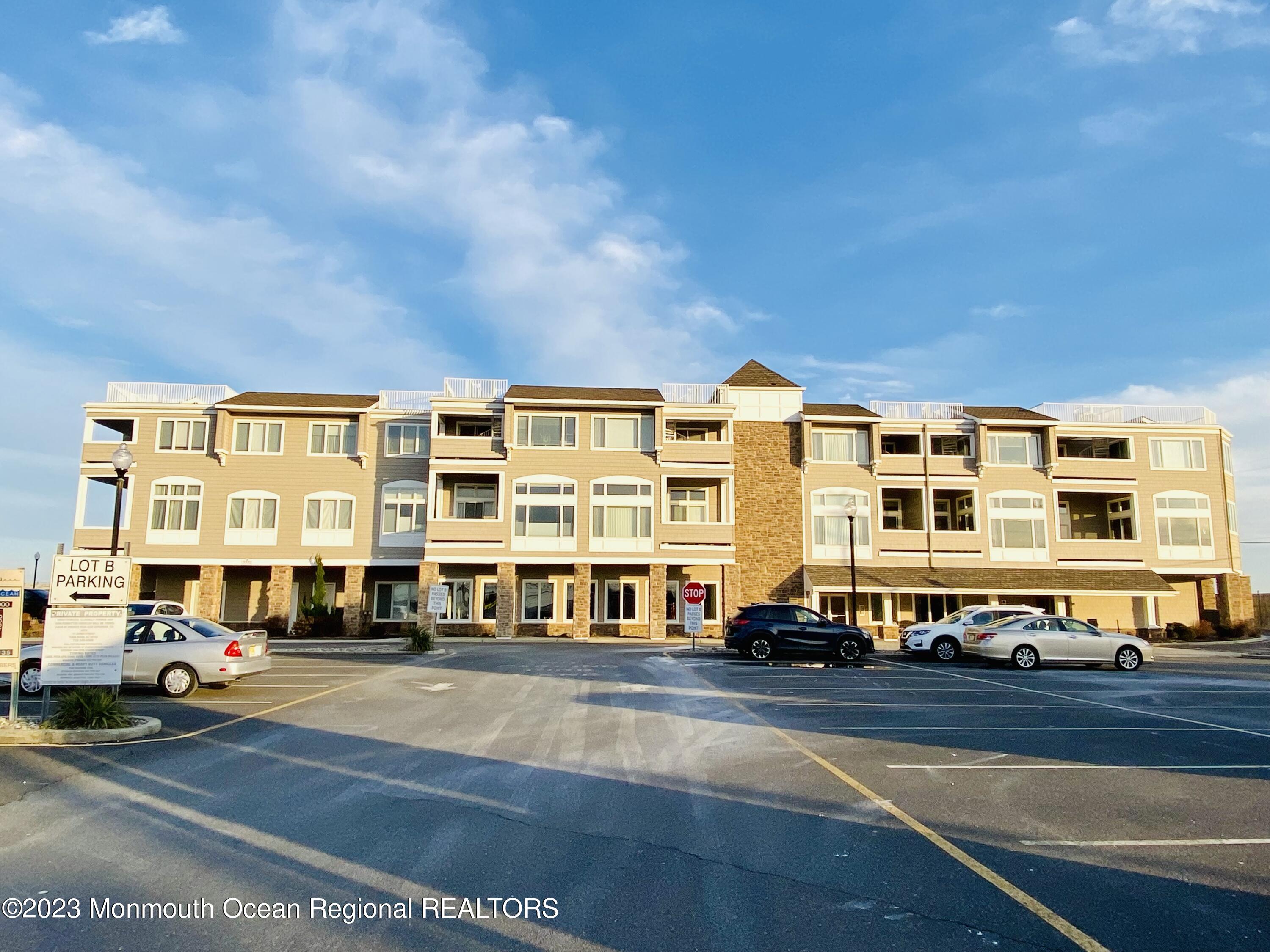 a front view of a building with lot of cars