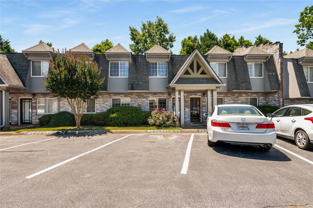 a front view of a house with a garden and parking space