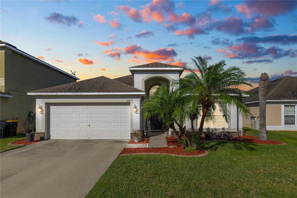 a front view of a house with a yard and garage