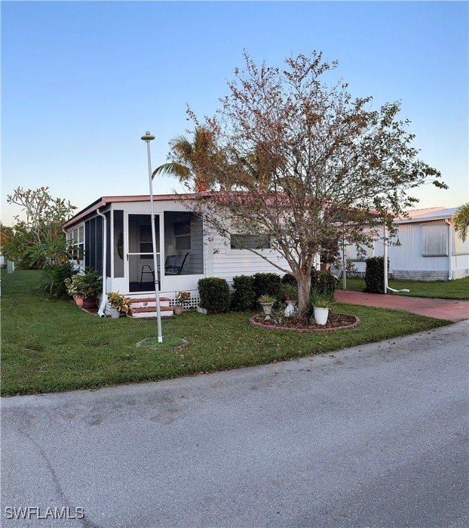 a front view of a house with a yard and trees