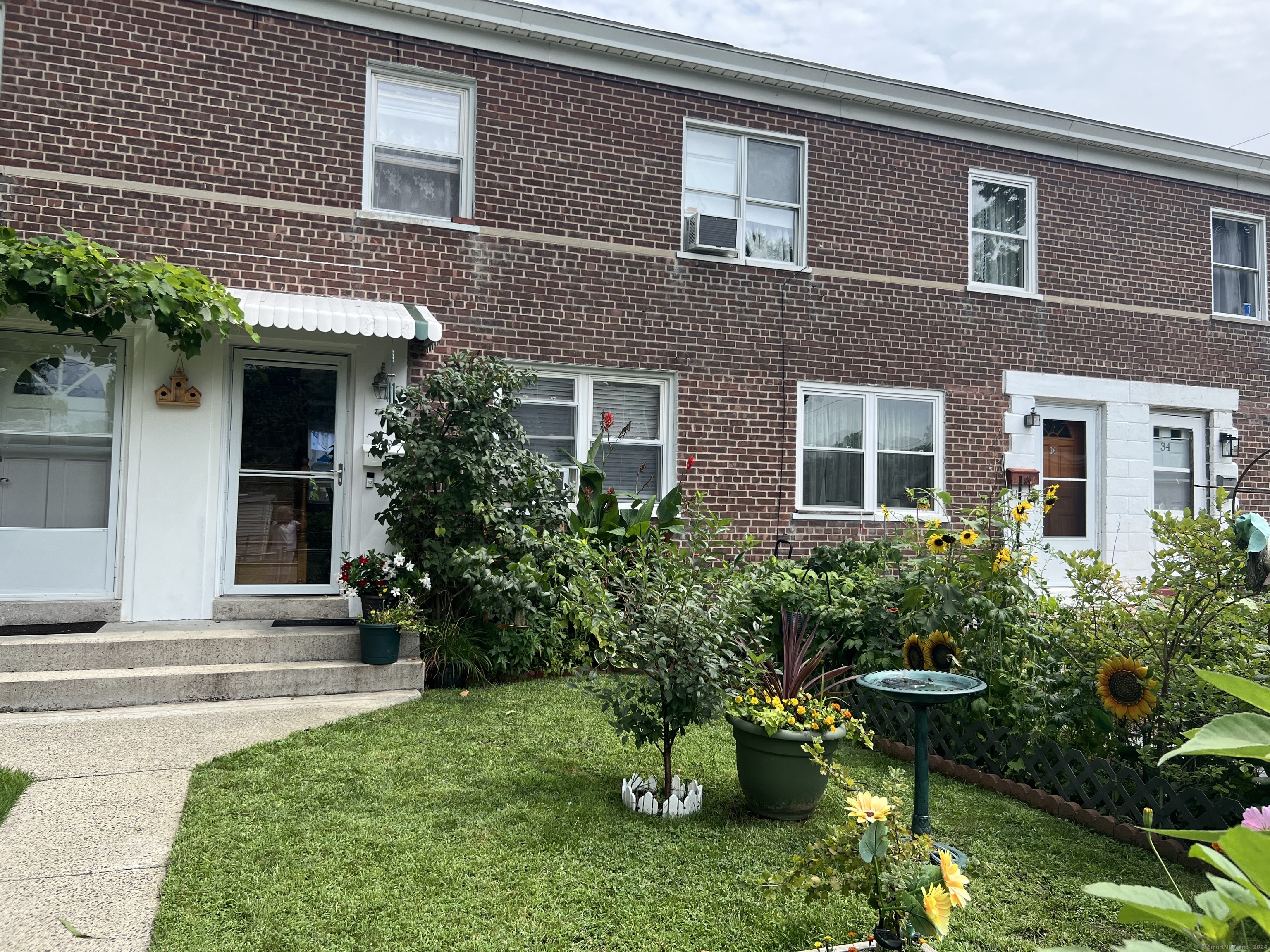 a yellow house with potted plants in front of it