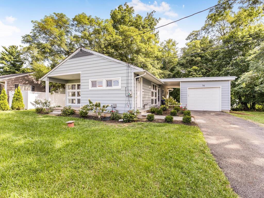 Single story home featuring a garage and a front lawn