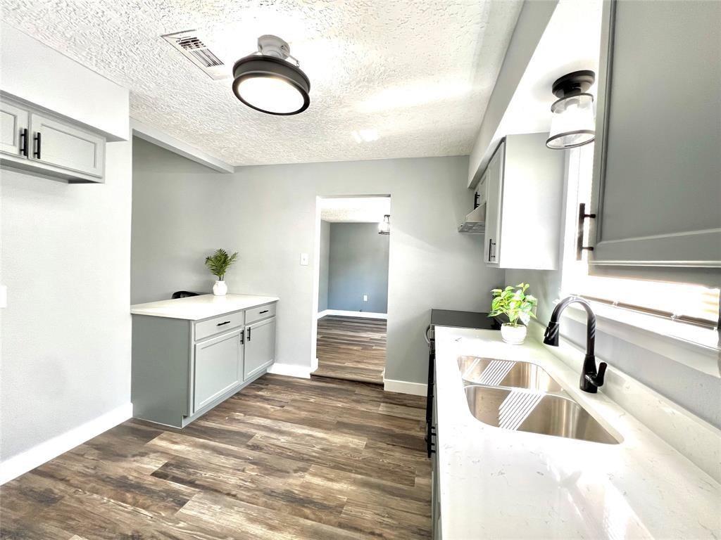 a large white kitchen with granite countertop a sink