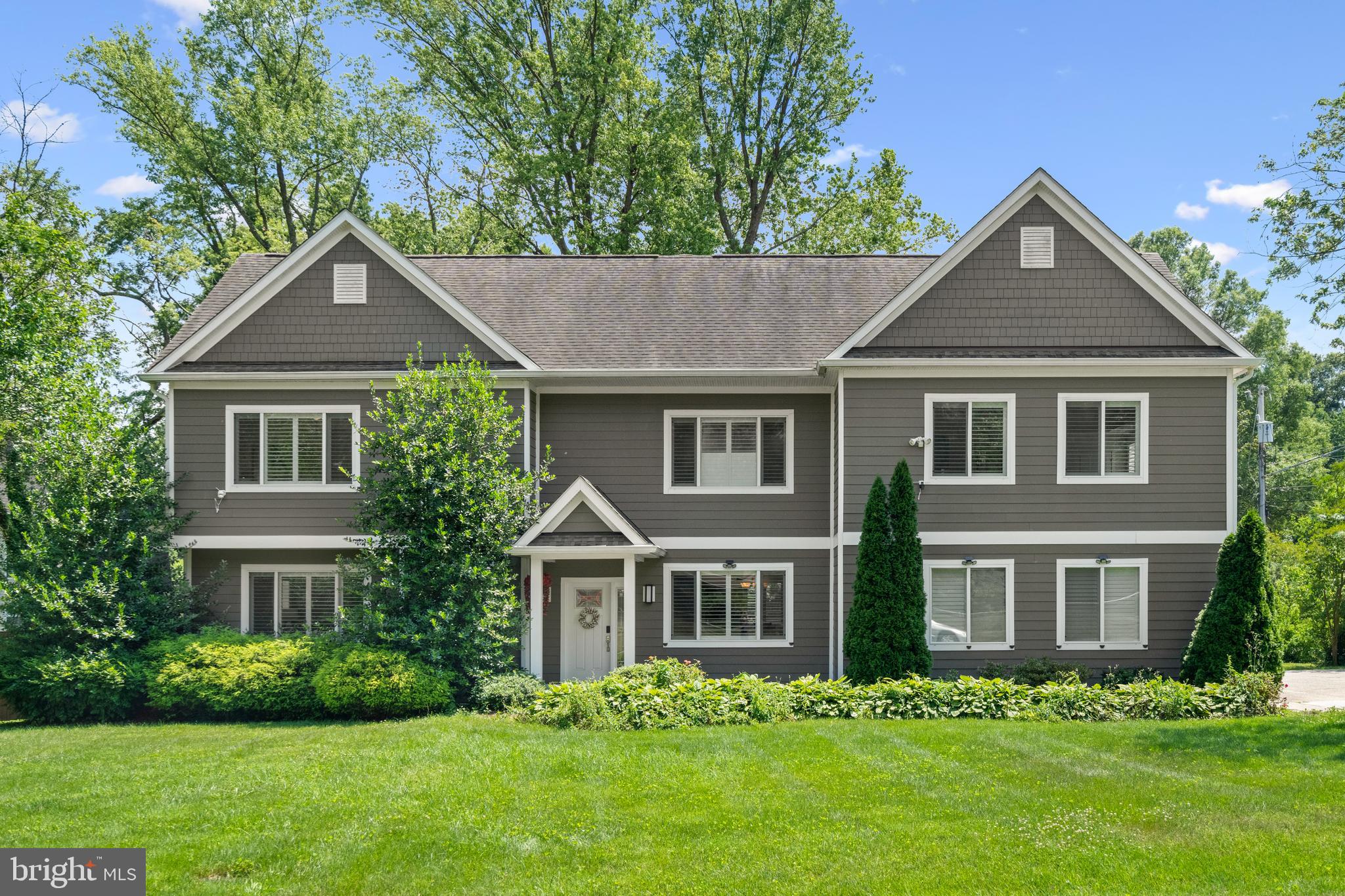 a front view of a house with a yard and trees