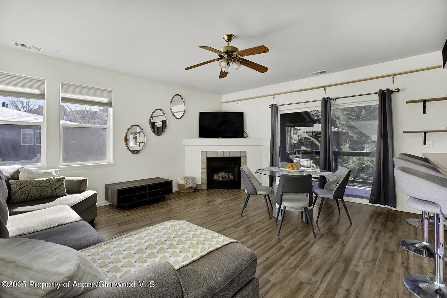 a living room with furniture a fireplace and a floor to ceiling window