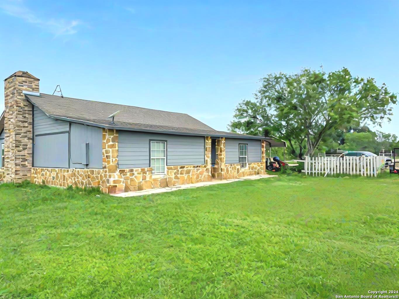 a view of a house with a yard and sitting area