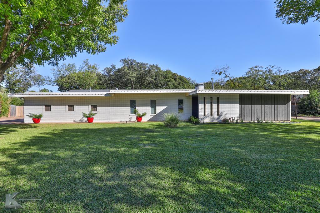 a view of a house with a backyard and a tree