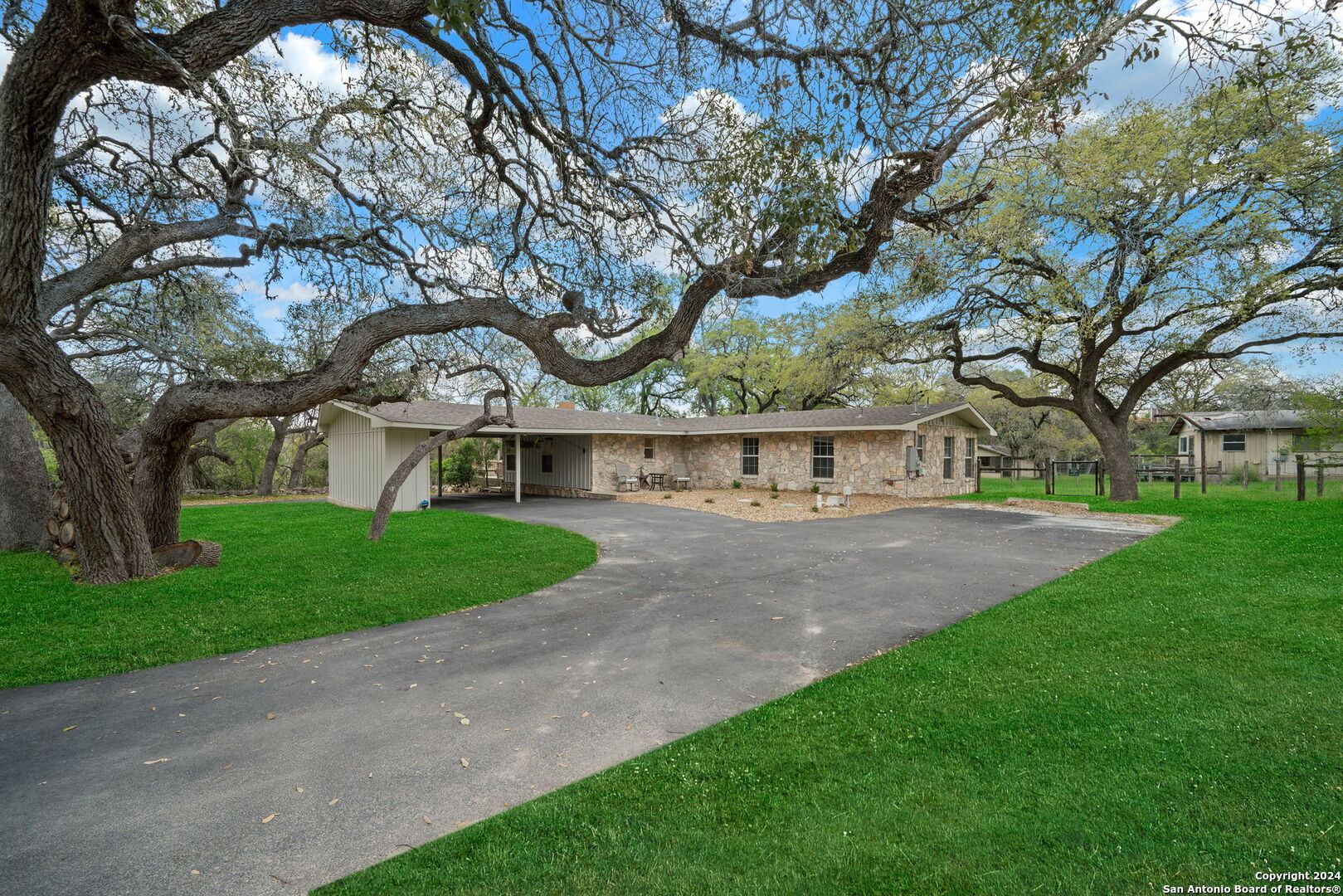 a view of a big house with a large tree and large trees