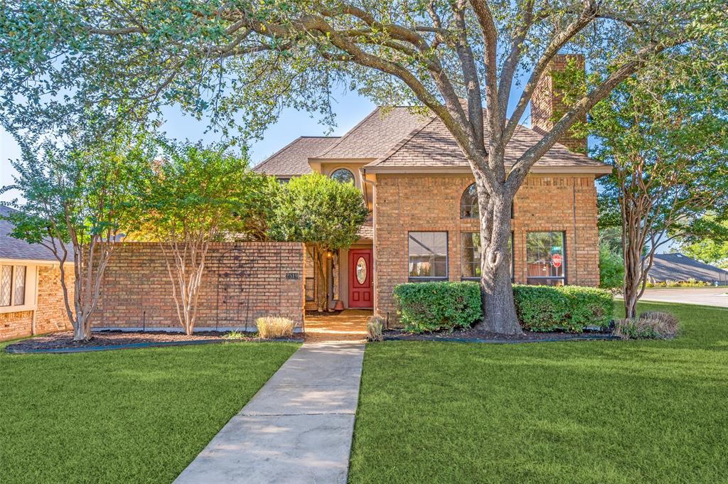 a front view of a house with a yard and an tree