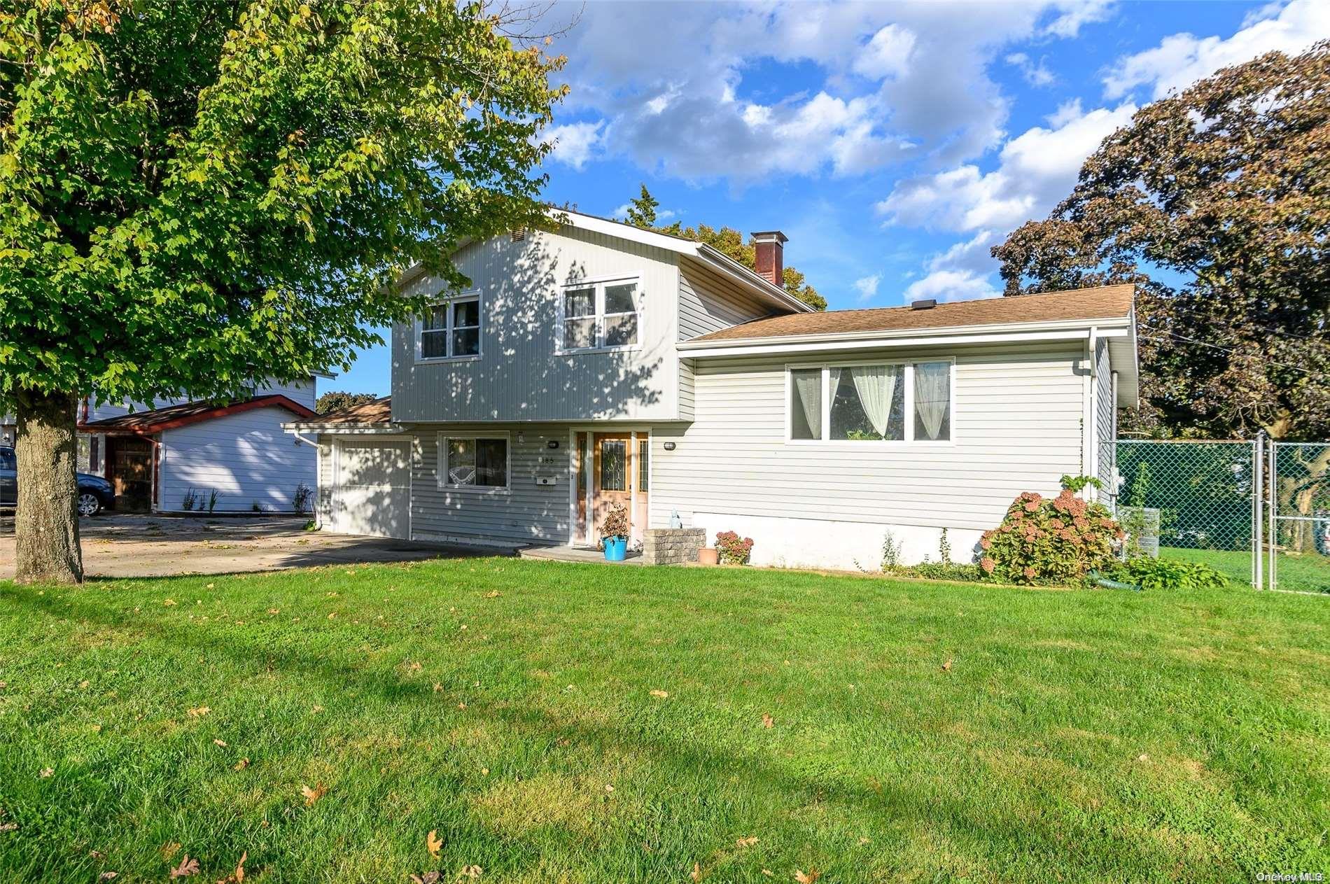 a front view of a house with a garden and yard