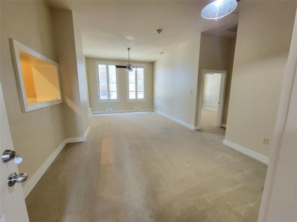 an empty room with windows and cabinet