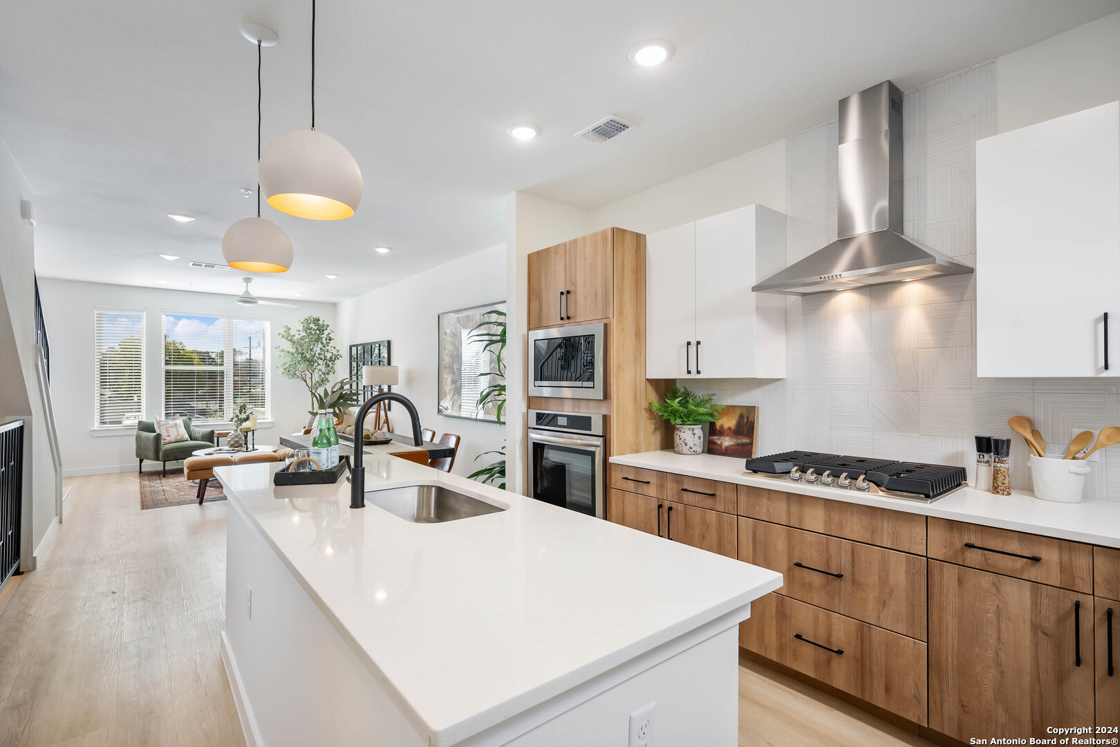 a kitchen with stainless steel appliances granite countertop a sink a stove and a wooden floors