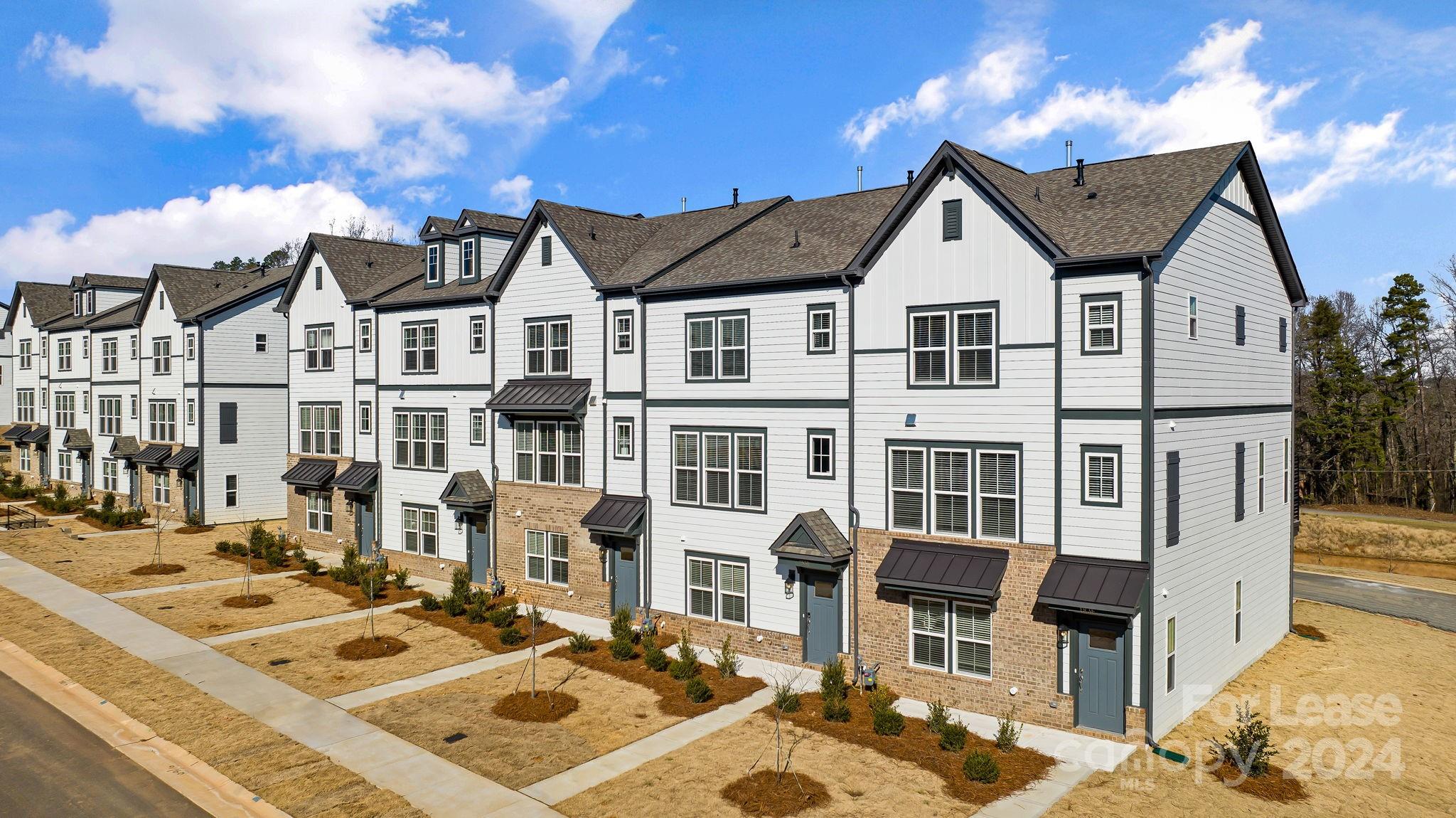 a front view of a residential apartment building with a yard