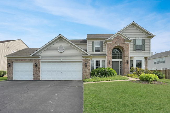 a front view of a house with a yard and garage