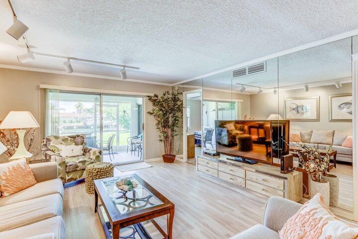 a living room with furniture a flat screen tv and a large window